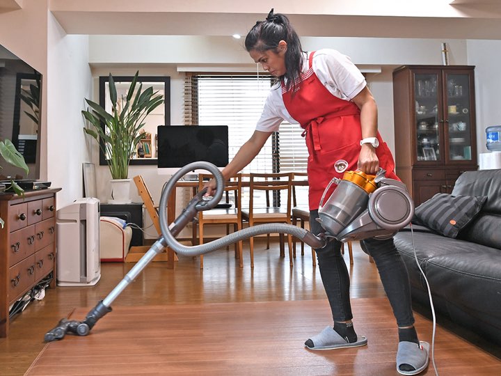 A woman is vacuuming the floor in her home.