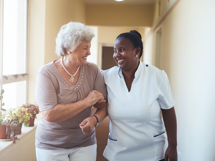 Two women are walking together in a hallway.