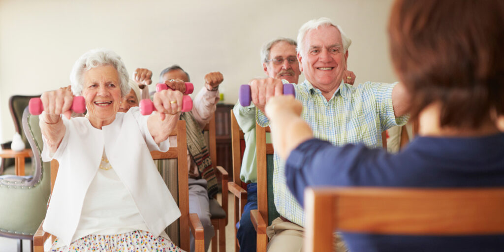 A group of people sitting in chairs holding exercise equipment.